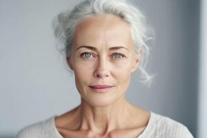 Beautiful mid aged mature woman looking at camera isolated on white. Mature old lady close-up portrait. photo