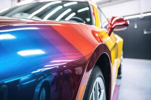 A close - up shot of a vehicle in a paint booth, as it undergoes the painting process. photo