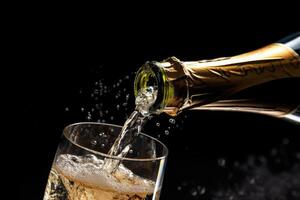 A close - up shot of a silver champagne bottle popping open, releasing sparkling bubbles into the air. photo