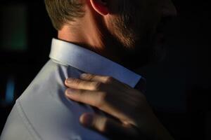 Close - up view of a man rubbing his neck and shoulder area, indicating discomfort and tension. Generative AI photo