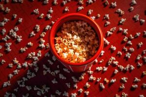 An overhead shot of a spilled popcorn tub on the cinema floor. photo