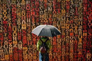 un niño participación un paraguas debajo un lluvia de alfabetos, simbolizando el ducha de conocimiento. generativo ai foto
