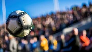 A focused photo of a ball in the air during a youth soccer team game