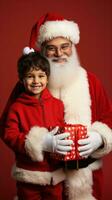 A santa claus and little boy stands isolated on a red background. photo