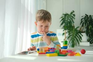 A little boy plays with wooden toys and builds a tower. Educational logic toys for children. Montessori games for child development. Children's wooden toy. photo