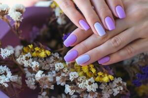 Women's hands with a fashionable very peri manicure against the background of dried flowers. Spring-summer nail design photo