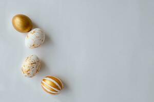 Top view Easter eggs painted with gold paint in various patterns . White background. Space for copy. photo