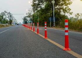 A low-angle view of many reflective orange plastic poles set up as a sign to prevent oncoming traffic. photo