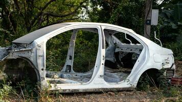 lado ver de un blanco coche naufragio, desmantelado a sus acero marco. foto