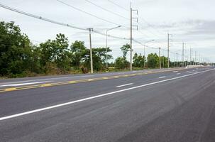 ver de nuevo asfalto la carretera con blanco flechas y otro símbolos extensión. foto