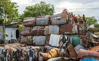 Views of piles of scrap metal that have been crushed and compressed into rods and tied together. photo