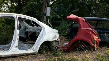 lado ver de un blanco y rojo coche ruina desmontado a sus acero marco. foto