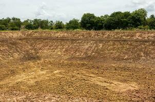 A background view of the shoreline, a mound of dirt dug into a canal or a large pond. photo