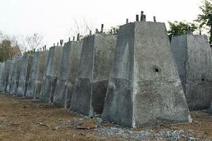 Numerous concrete pillar bases, which were built by cement casting in a steel box and lined up in rows. photo