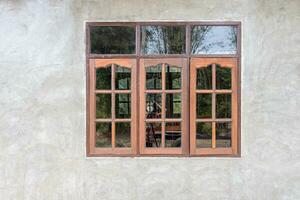 A gray concrete wall background decorates an old wooden glass window. photo