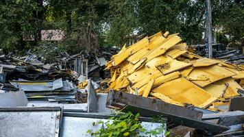 View of large piles of scraps of steel sheets and old yellow styrofoam piled up. photo