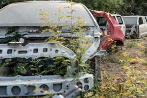 A rear view of the wreckage of a white car and others. photo