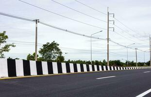 A close-up view of a black-and-white striped concrete barrier. photo