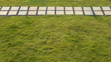 A view from above against a backdrop of unevenly growing fresh green lawns with concrete block slabs. photo