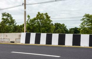 A close-up view of a black-and-white striped concrete barrier. photo