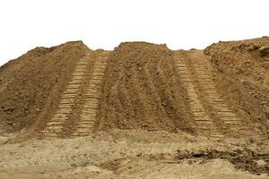 Isolate mounds of sandy brown soil that have been excavated and poured together. photo