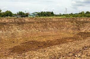 A background view of the shoreline, a mound of dirt dug into a canal or a large pond. photo