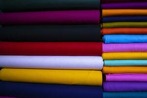 Artistic variety shade tone colors Textile Fabrics stacked on retail Shop Shelf to sale photo