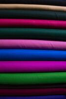 Artistic variety shade tone colors Textile Fabrics stacked on retail Shop Shelf to sale photo