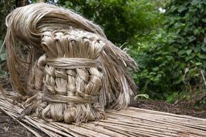 A thick brown  bundle of raw jute has on the ground photo