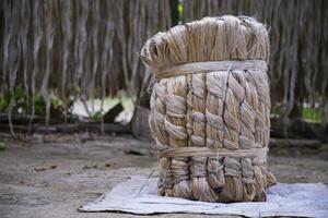 A thick brown  bundle of raw jute has on the ground photo