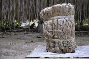 A thick brown  bundle of raw jute has on the ground photo