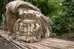 A thick brown  bundle of raw jute has on the ground photo