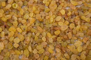 Dried fruits Yellow sweet delicious raisins pattern texture can be used as a background wallpaper photo