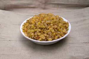 A Bowl of Delicious sweet raisins on the Jute fiber fabric photo