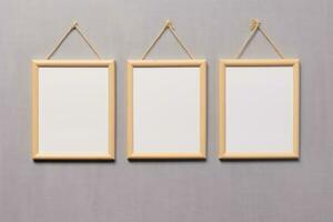 Three Wooden Frames Hanging on a Rope on a Gray Wall AI Generated photo