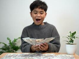 The boy joyfully holds the money. Money saving concept, investment, finance. photo