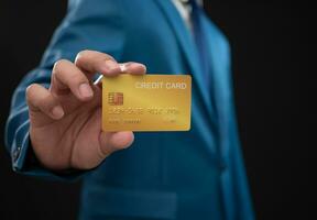 Businessman holding credit card on dark background. Shopping concept. Cashless spending concept. loan concept photo