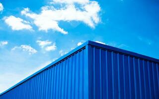 Blue warehouse roof with sky and clouds background photo