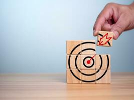 Businessman hands are completing wooden blocks with target sign. Startup concept. Business concept. Management concept. Business planning concept. photo