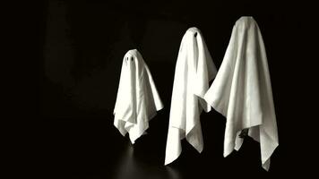A group of ghost white sheet costume flying in the air with black background. Minimal Halloween scary concept. video