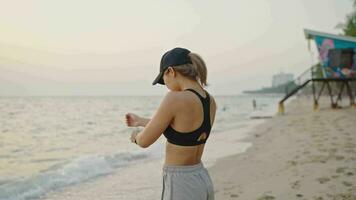 jong vrouw in bodysuit beoefenen yoga Aan de strand bovenstaand zee Bij verbazingwekkend zonsopkomst. fitheid, sport, yoga en gezond levensstijl concept. video