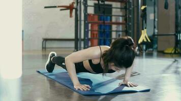 Frau tragen trainieren Kleider auf ein Yoga Matte tun etwas drücken UPS ein das Fitnessstudio. video