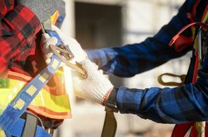 construcción trabajador preparando la seguridad en trabajo ropa antes de instalando nuevo techumbre herramientas techumbre herramientas, eléctrico simulacros y usado en nuevo de madera techos con metal hojas foto