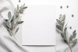 Blank greeting paper card, invitation mockup scene top view with eucalyptus tree branches. Elegant stationery on white table background. photo