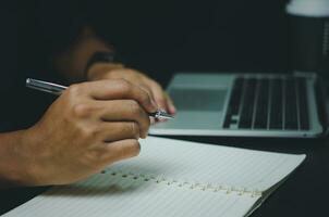 Businessman hands with pen writing notebook information in journal, reports, diary. photo