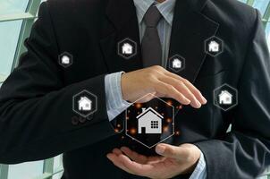 man in suit holding house icon with home network icons photo