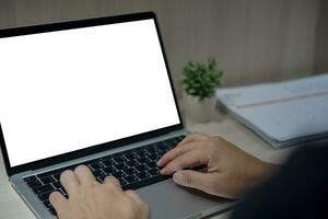 person hand using keyboard laptop computer mock up blank white screen on desk. photo