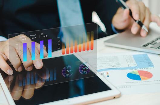 Businessman using tablet with statistics, graph and chart virtual hologram of statistics.Data analytics and statistics. business marketing investment and financial concept. photo