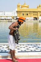 Amritsar, India - May 31 2023 - Unidentified devotees taking holy dip in sarovar at Golden Temple - Harmandir Sahib in Amritsar, Punjab, India, Famous indian sikh landmark, Golden Temple photo