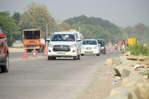 New Delhi, India - April 16, 2023 - View of Vehicles passing through the main road near Indra Gandhi International Airport Delhi at Dwarka link road photo